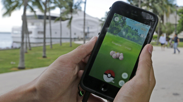 Exeggcute, a Pokemon, is found by a Pokemon Go player, Tuesday, July 12, 2016, at Bayfront Park in downtown Miami. The "Pokemon Go" craze has sent legions of players hiking around cities and battling with "pocket monsters" on their smartphones. It marks a turning point for augmented reality, or technology that superimposes a digital facade on the real world. (AP Photo/Alan Diaz)